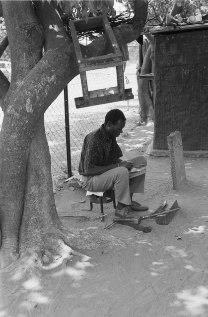 Sekuru Chigamba making mbira in his outdoor workshop, located at his home in the Zororo neighborhood of Highfield, a high-density township of Harare.